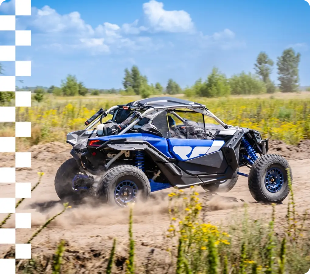 Blue side-by-side kicking up dust in field
