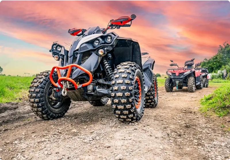 ATVs on dirt path under vibrant sky.