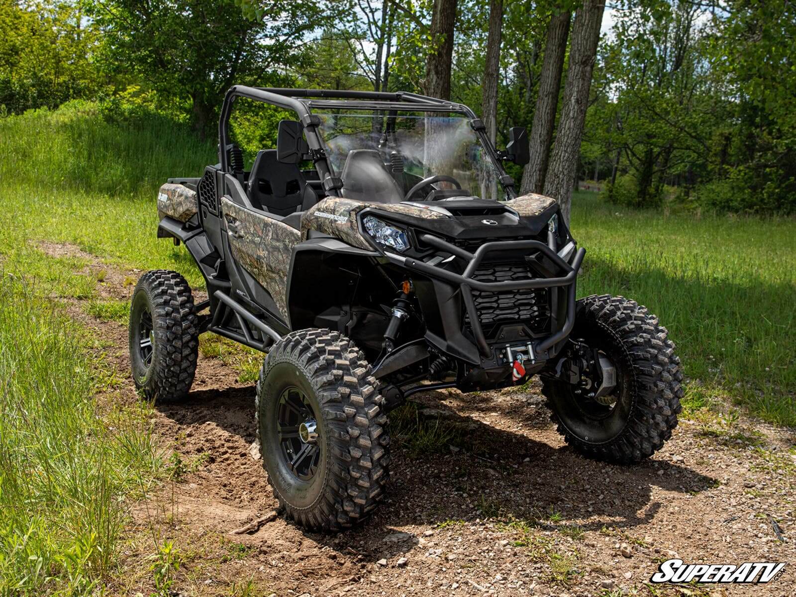 A rugged black off-road ATV parked in a forest clearing.
