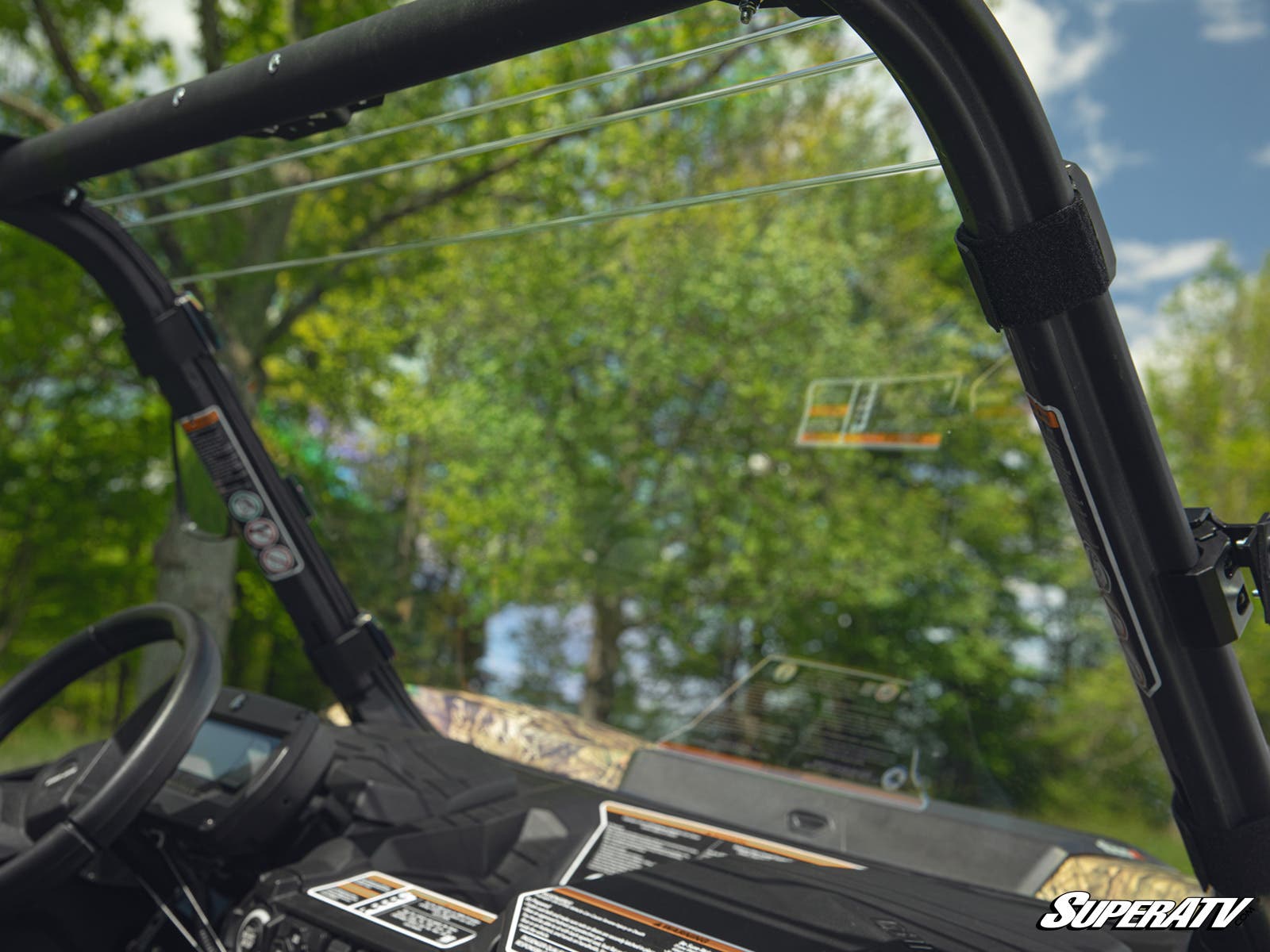 Inside view of a vehicle with a focus on the dashboard and outside greenery.