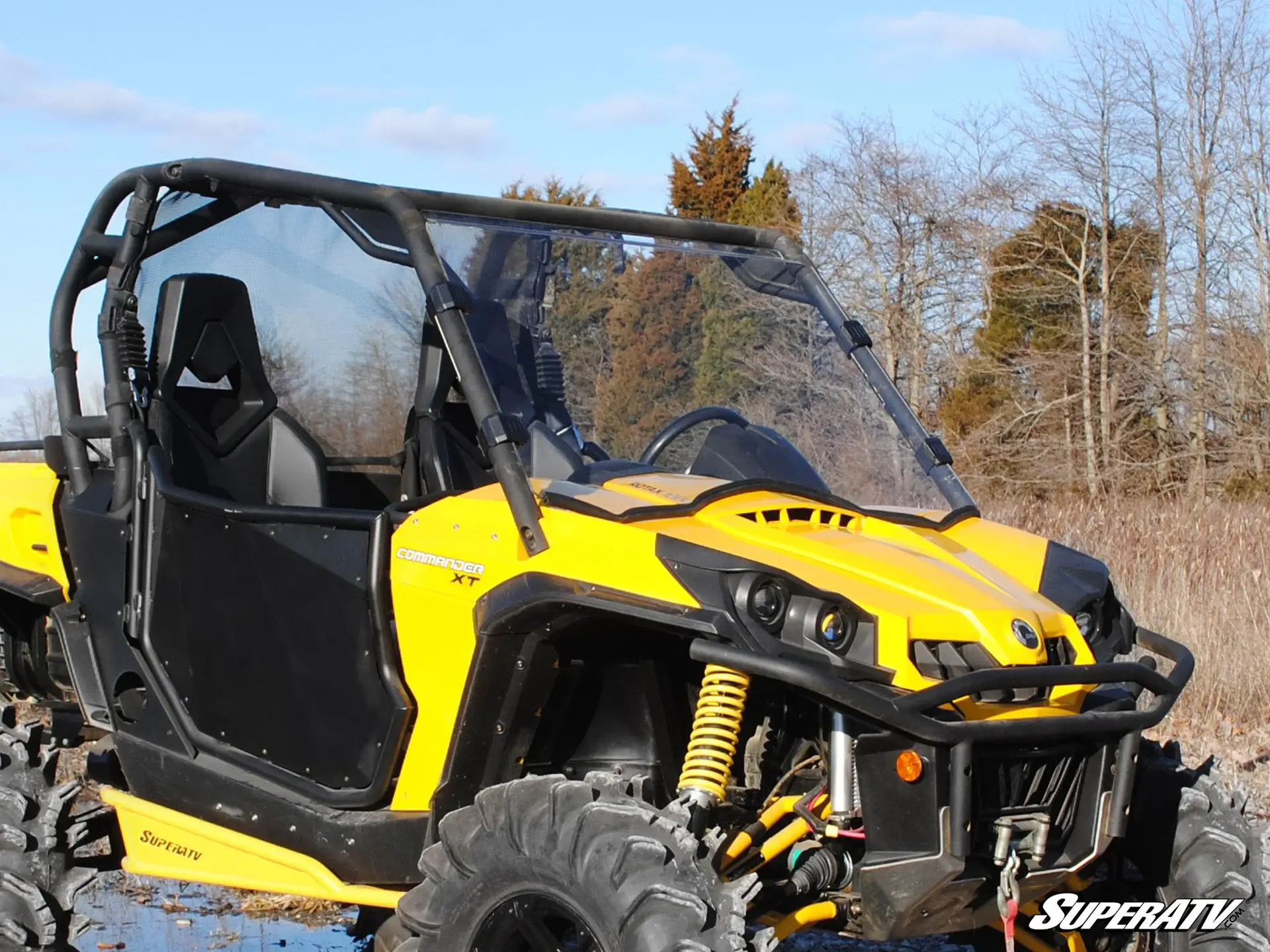 Yellow off-road dune buggy parked outdoors on a dirt path.