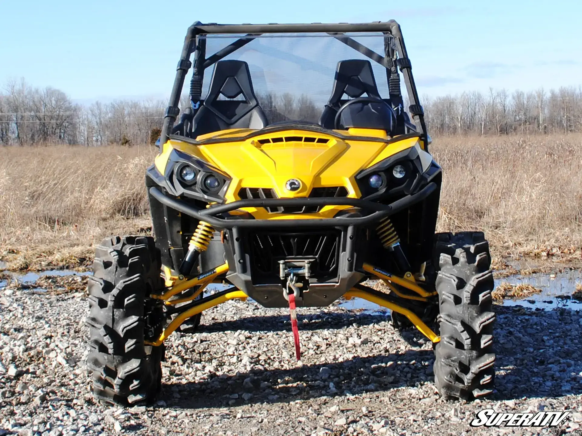 Yellow off-road buggy with large tires on a dirt path.