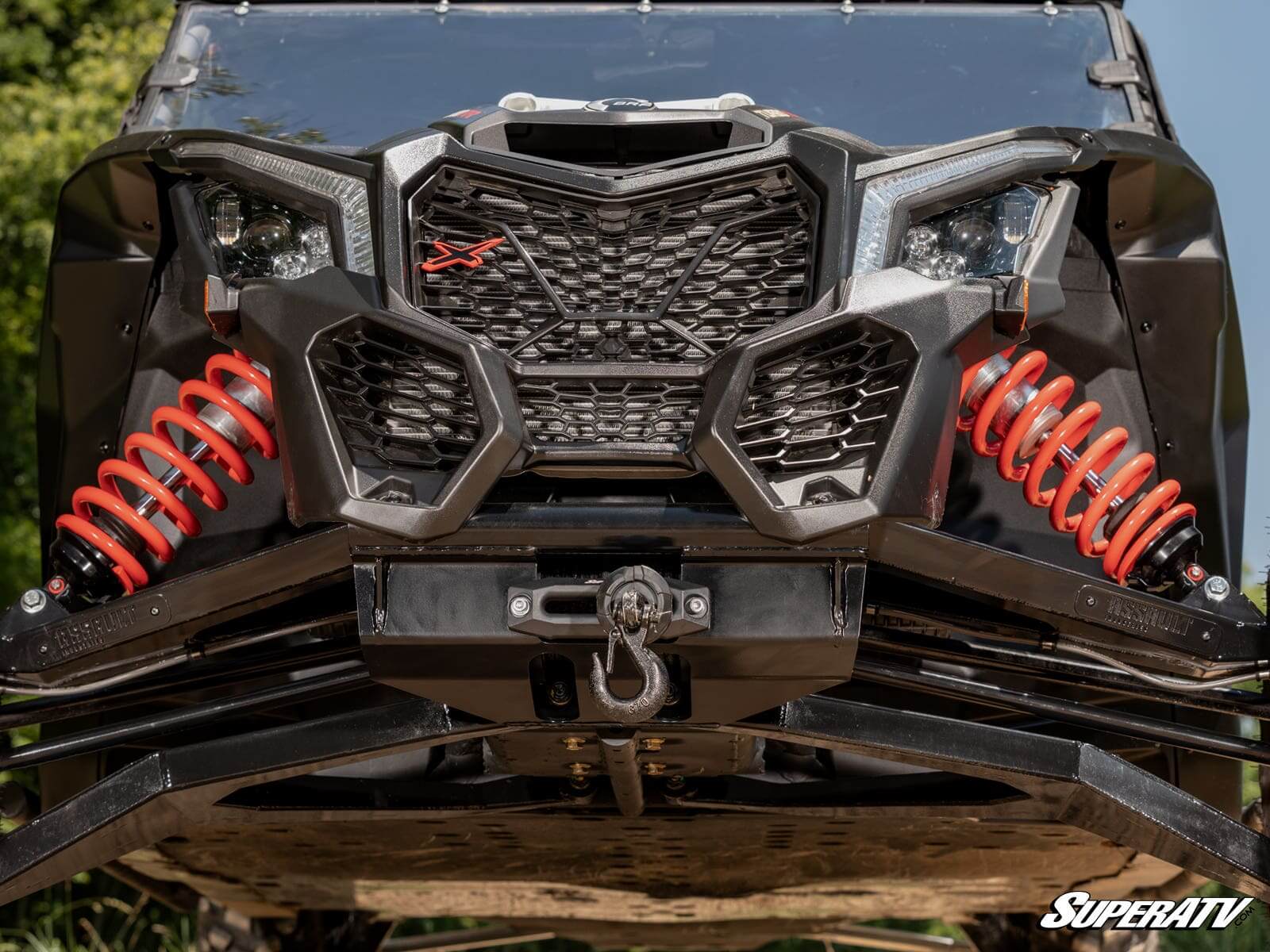 Close-up of a rugged off-road vehicle front with red suspension springs.