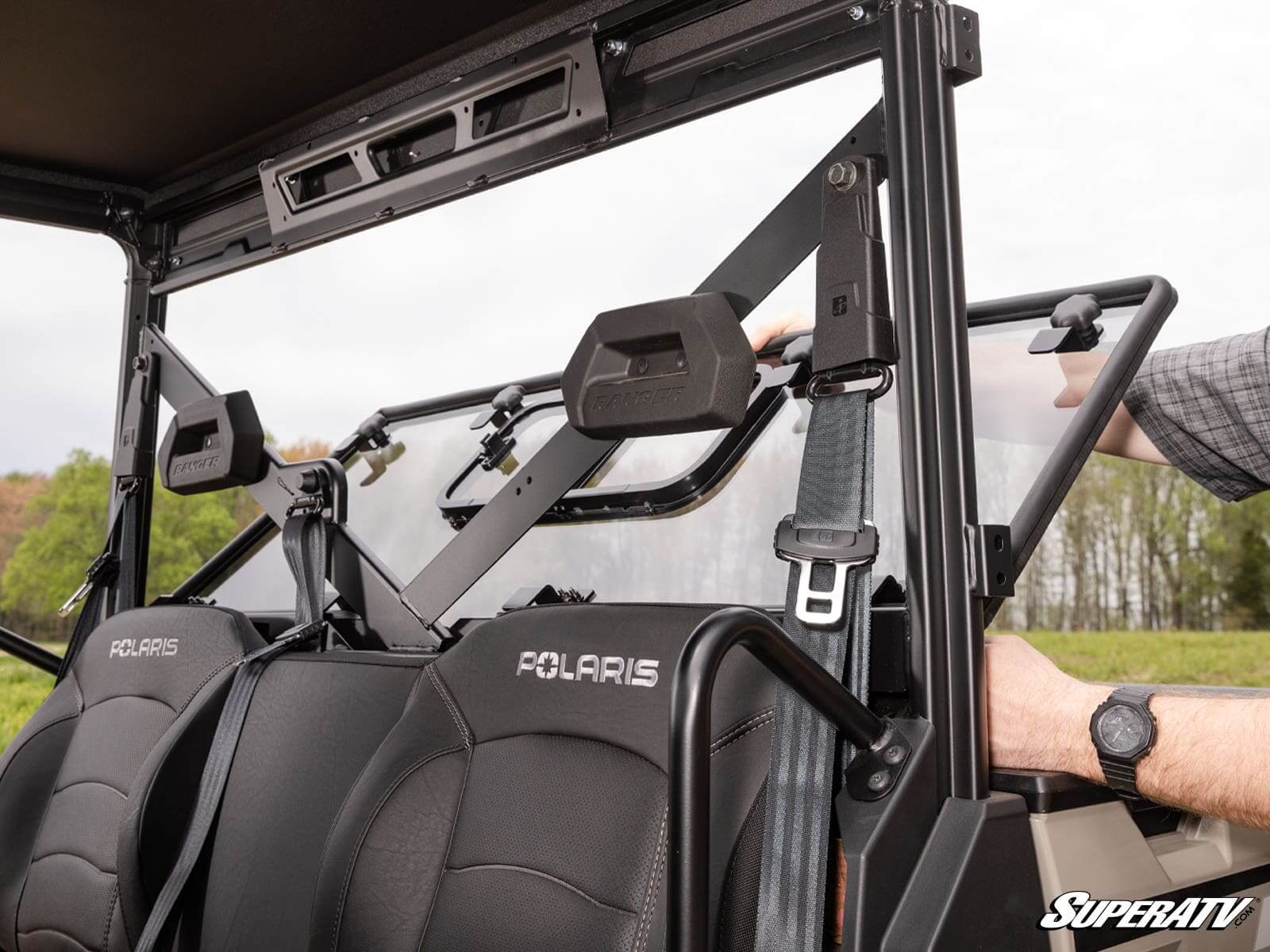 Close-up of an off-road vehicle's roll cage and seat with Polaris branding.