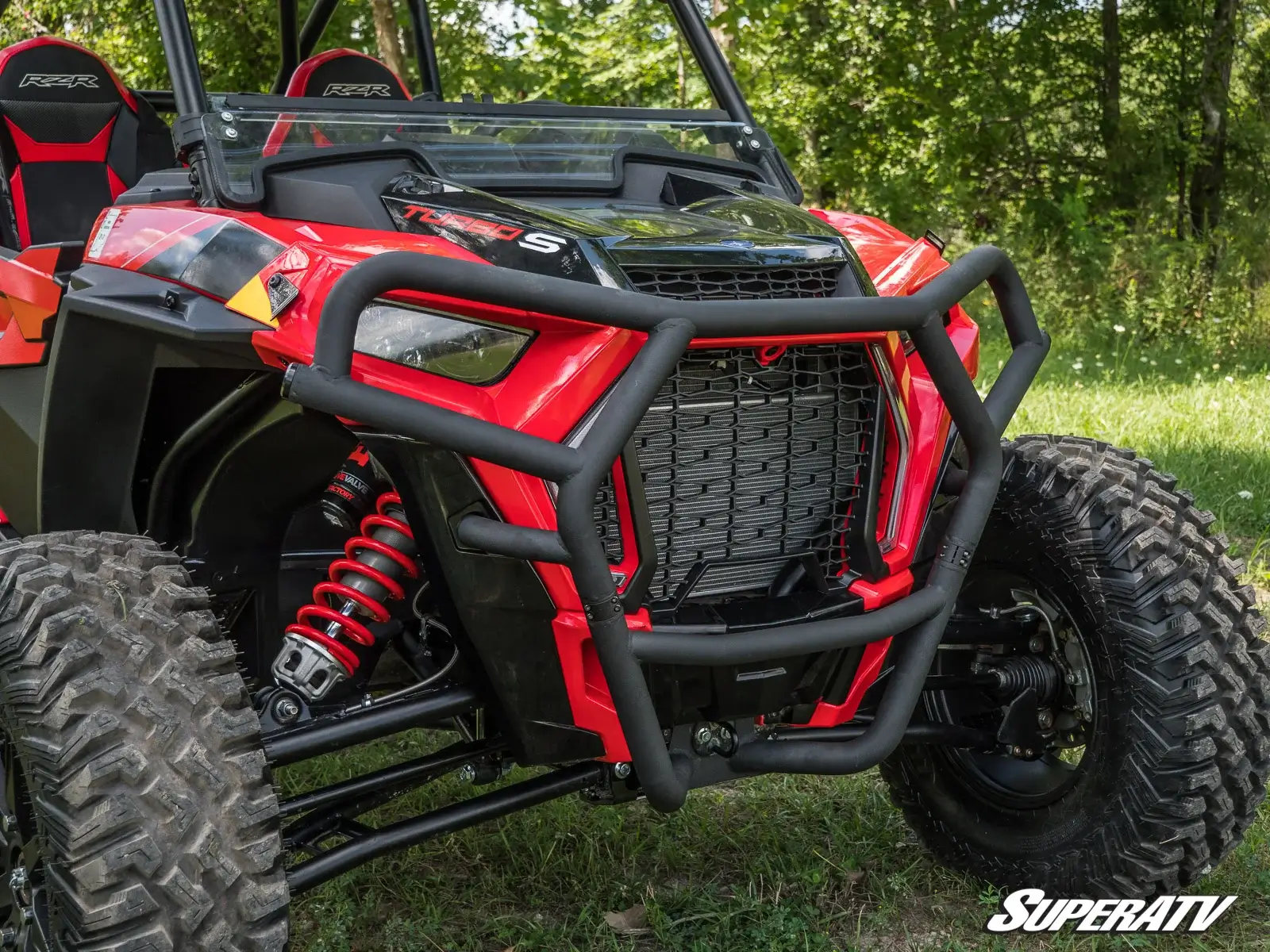Red off-road vehicle with rugged grille and suspension.