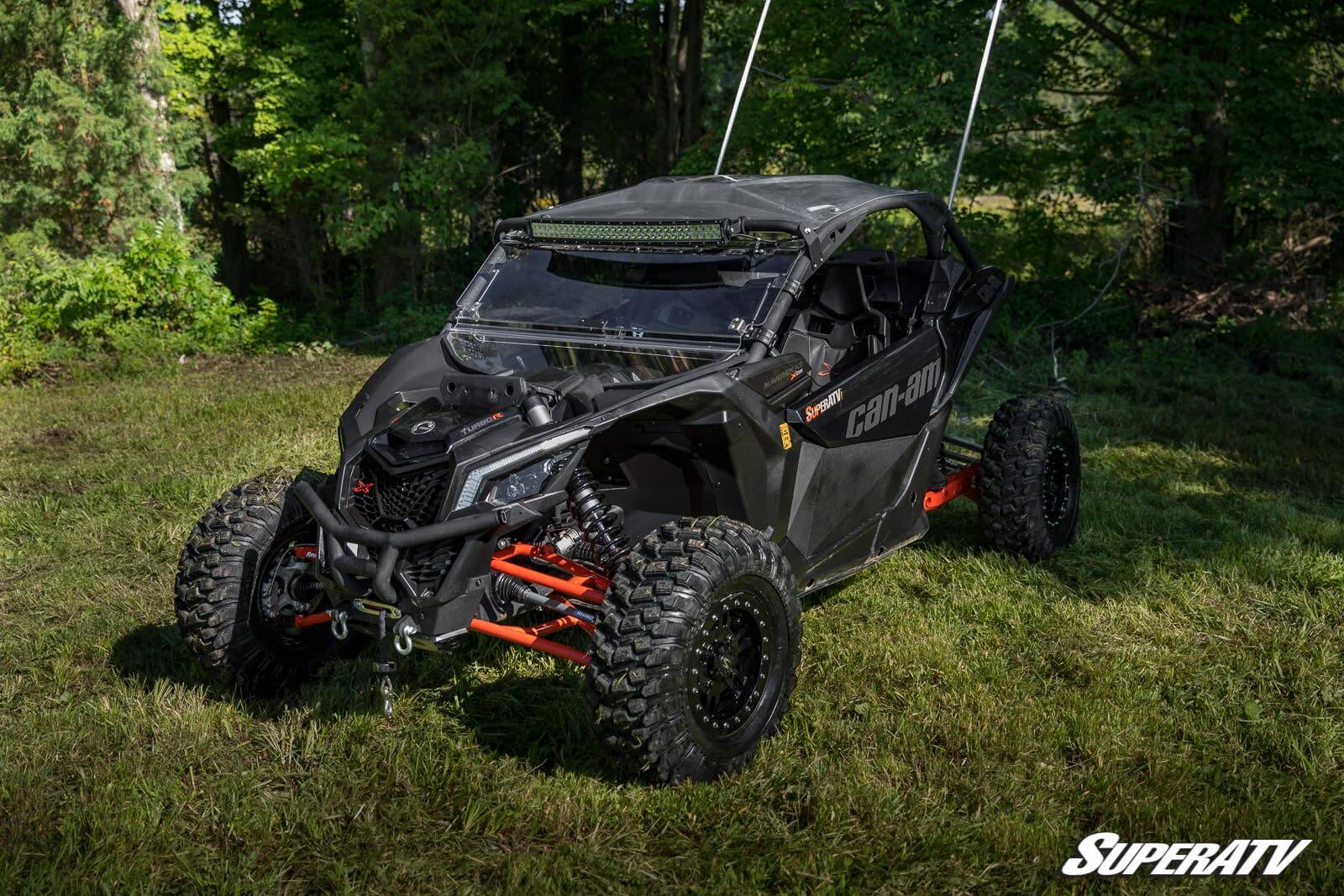Black off-road buggy with large tires in a wooded area.