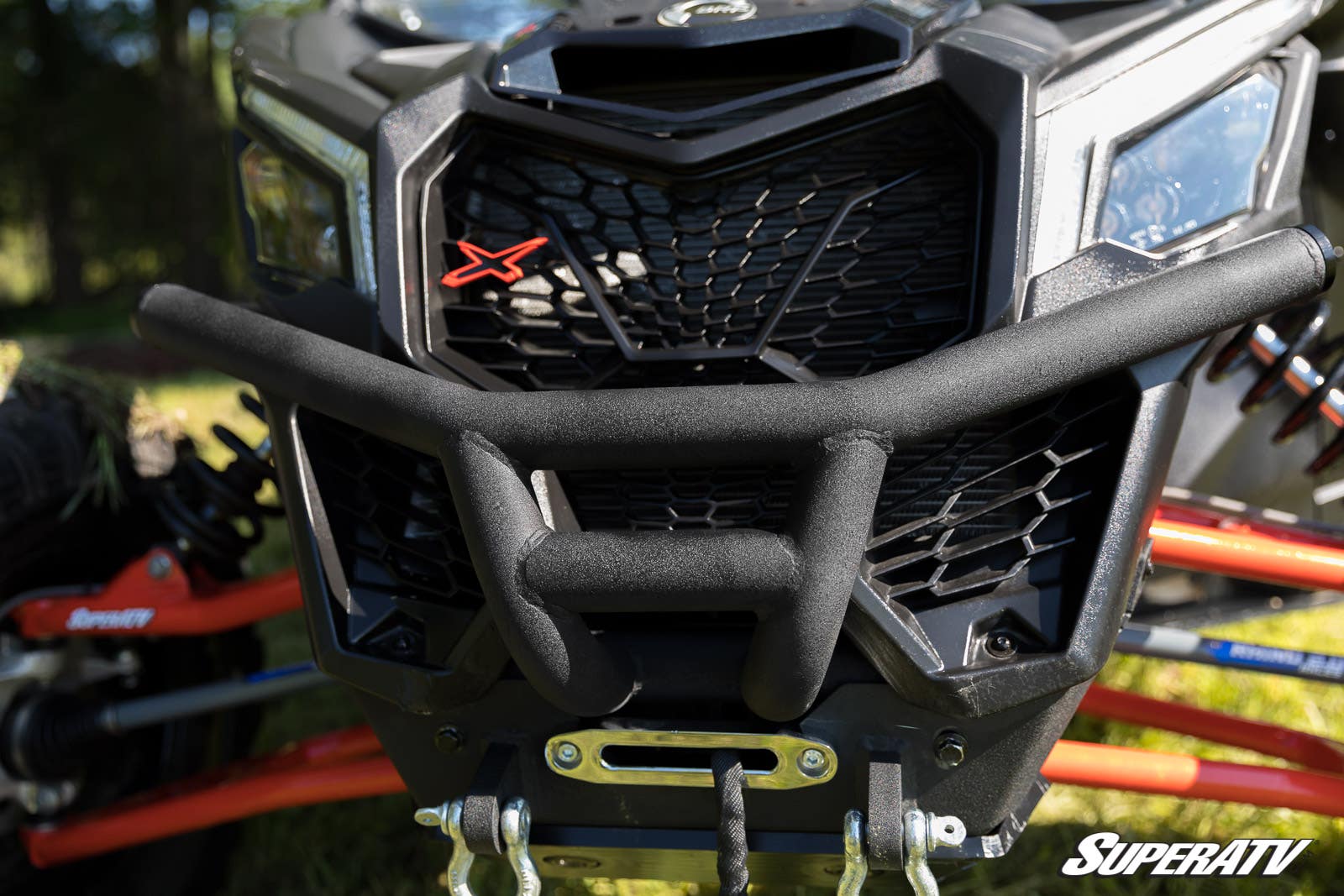 Close-up of a rugged vehicle front with a protective grille and winch.