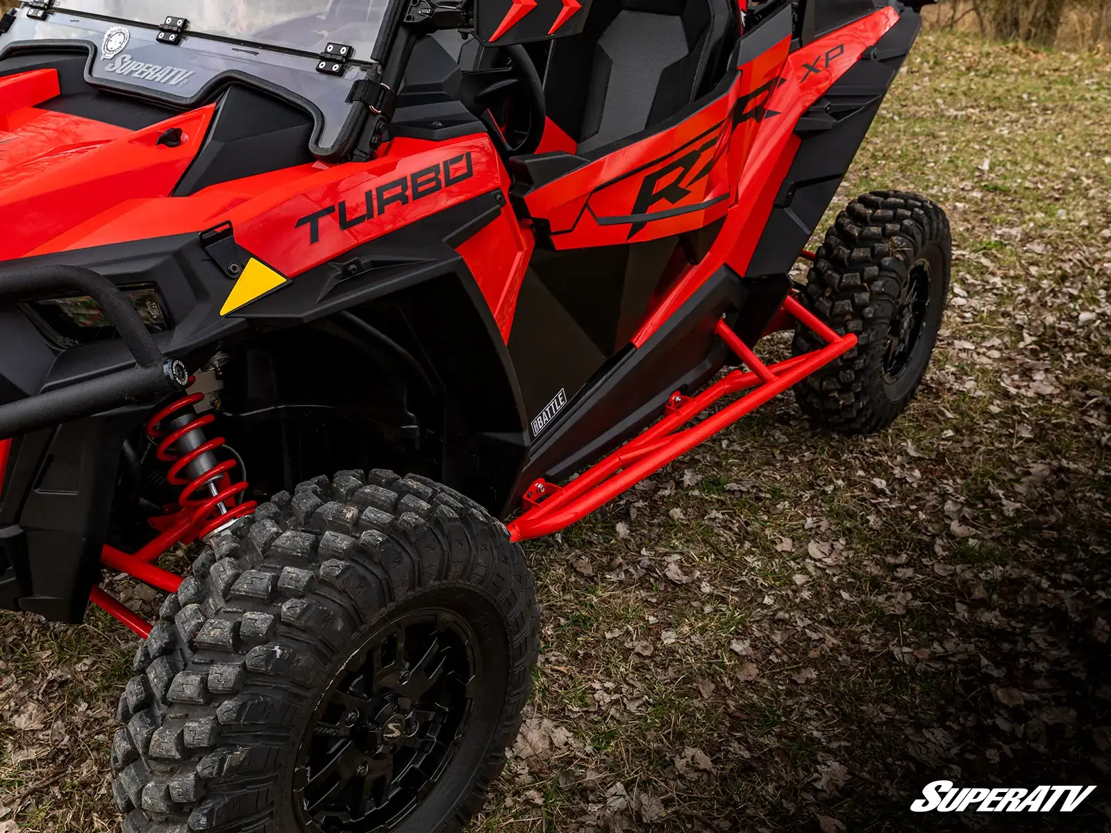 Red off-road vehicle on grassy terrain.