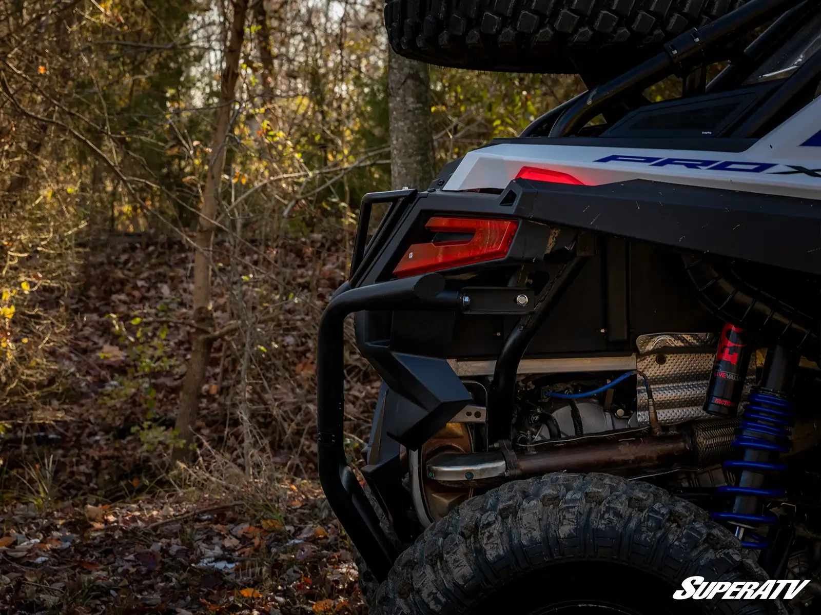Rear view of an off-road vehicle in a forest setting.