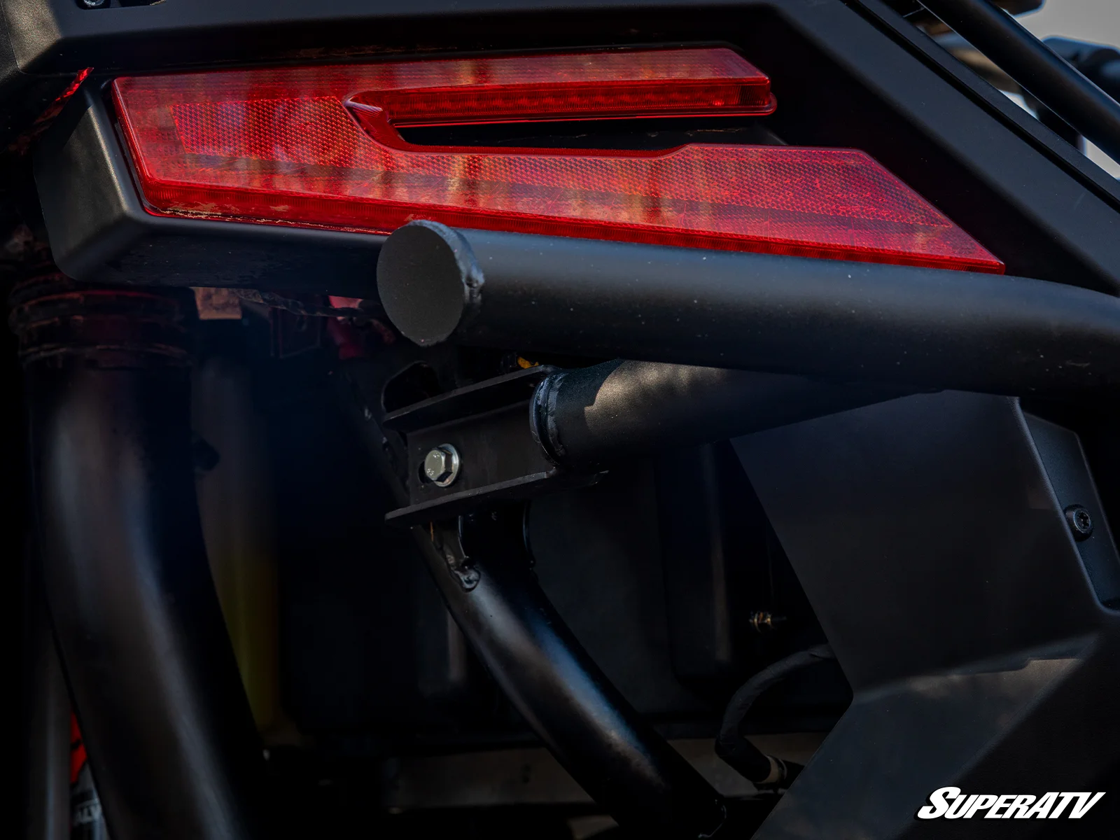 Close-up of a car's rear with a black spoiler and red taillight.